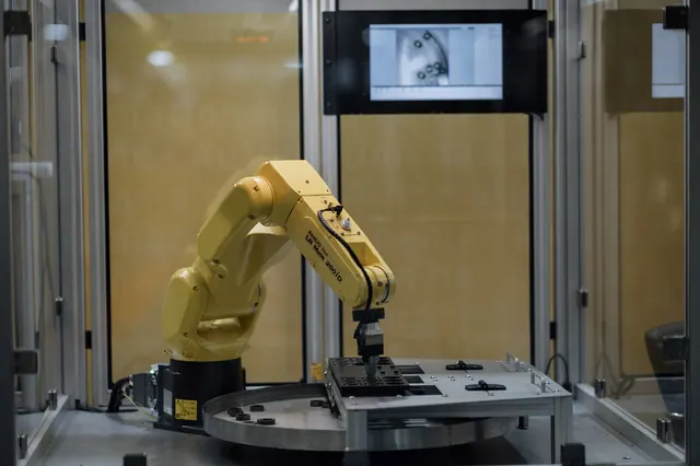 industrial robot arm assembling a component on a bench